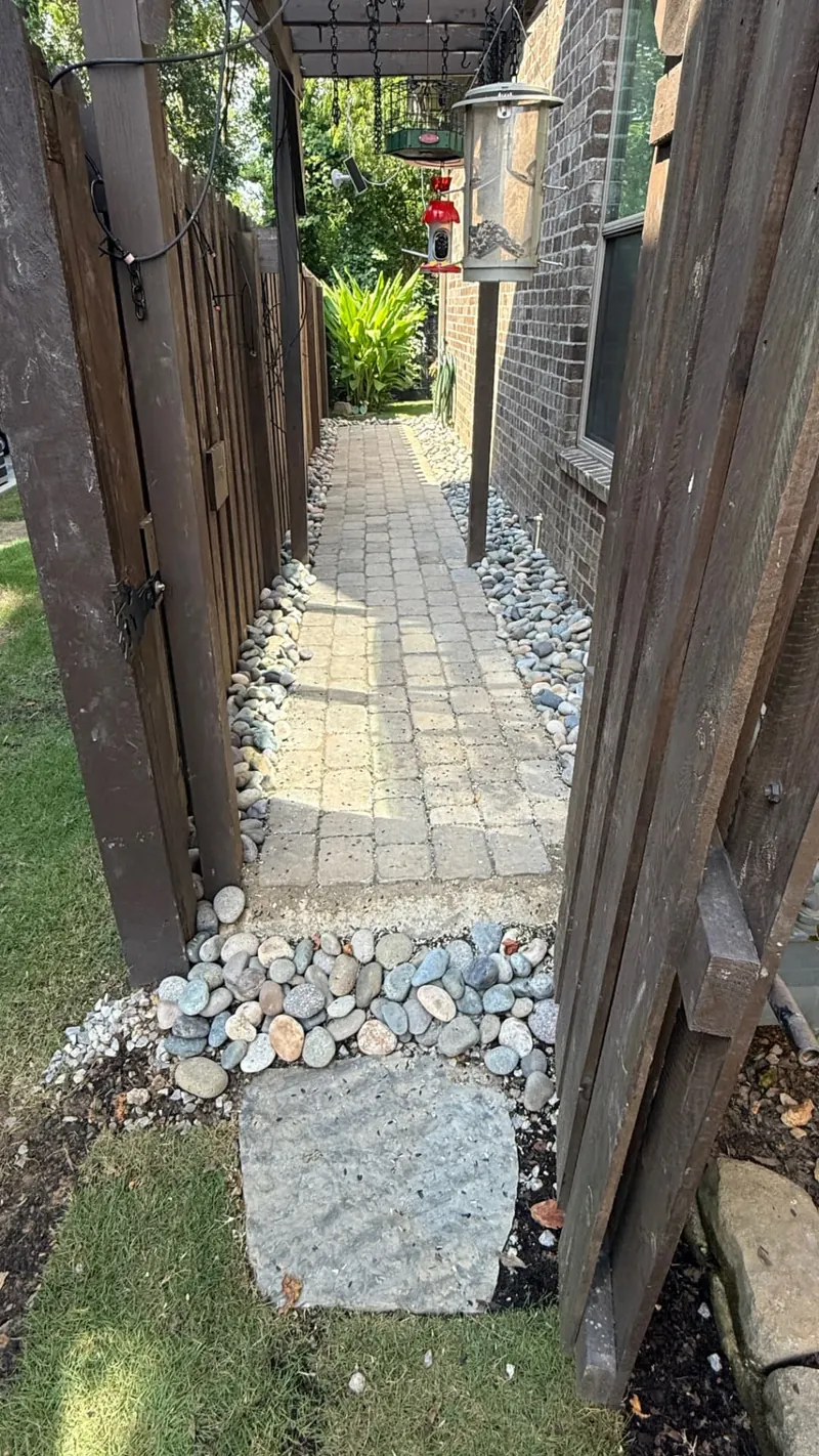 Paver patio and stacked stone wall installed by Growing Green Landscapes