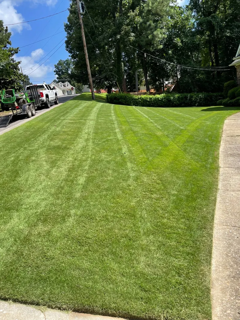 Growing Green Landscapes crew mowing and edging a lawn in Trussville, Alabama