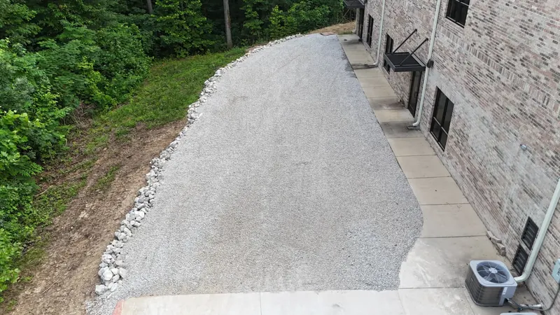 Gravel and rip rap drainage installation beside a building